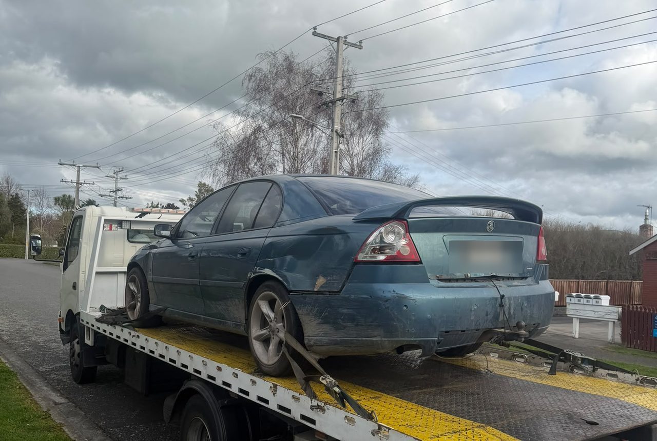 Old Holden Commodore loaded on a flatbed for scrap car removal in Rotorua